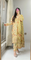 Person wearing a floral dress standing in front of a mirror in a room with a window and door.