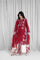 Woman wearing a red embroidered traditional outfit with white curtains in the background